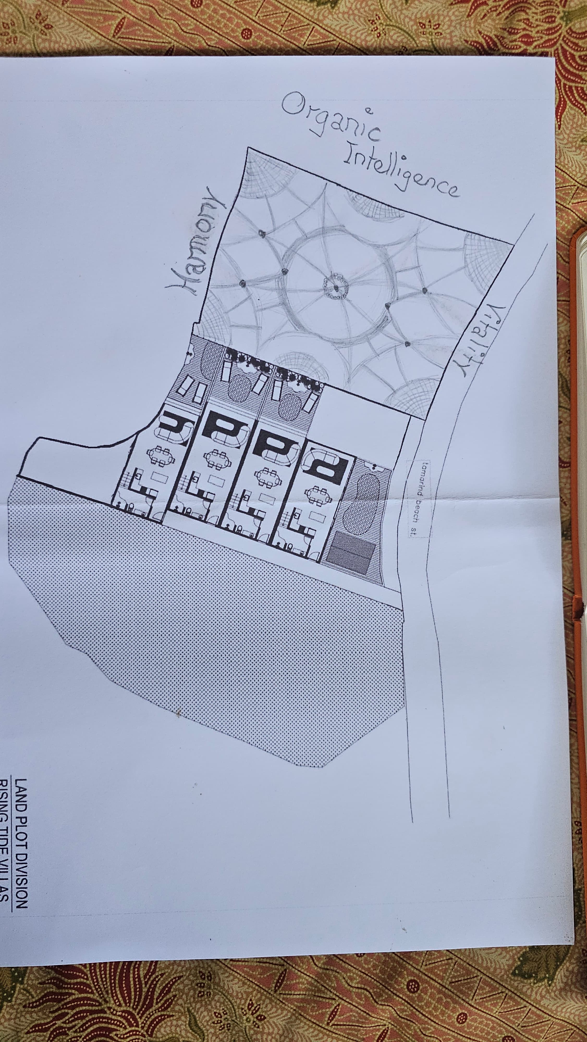 A printed land plot diagram labeled 'LAND PLOT DIVISION — RISING TIDE VILLAS' showing parcels along Tamarind Beach Street. Hand-drawn additions: 'Vitality' across the top road, 'Organic Intelligence' on the left, 'Harmony' at the bottom. A pencil mandala overlays the western half of the parcel.